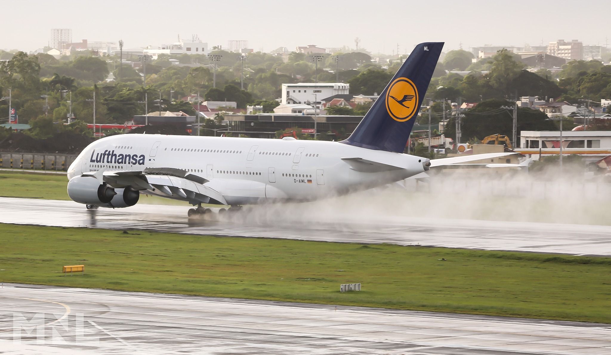 Lufthansa A380 (D-AIML) auf nasser Landebahn am Ninoy Aquino International Airport, Gischt aufwirbelnd nach der Landung.