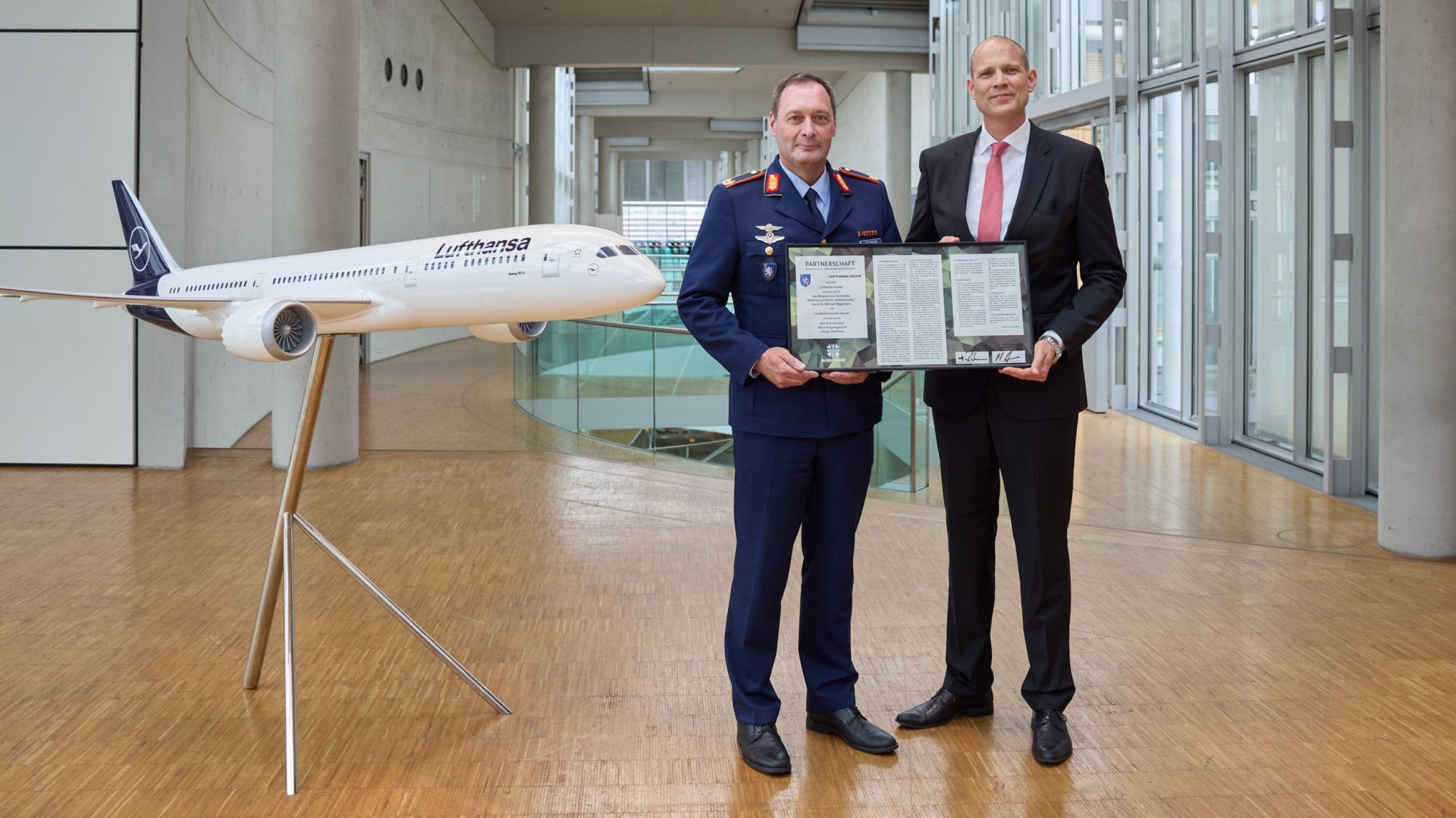 Lufthansa executive Michael Niggemann and Brigadier General Holger Radmann display a partnership certificate.
