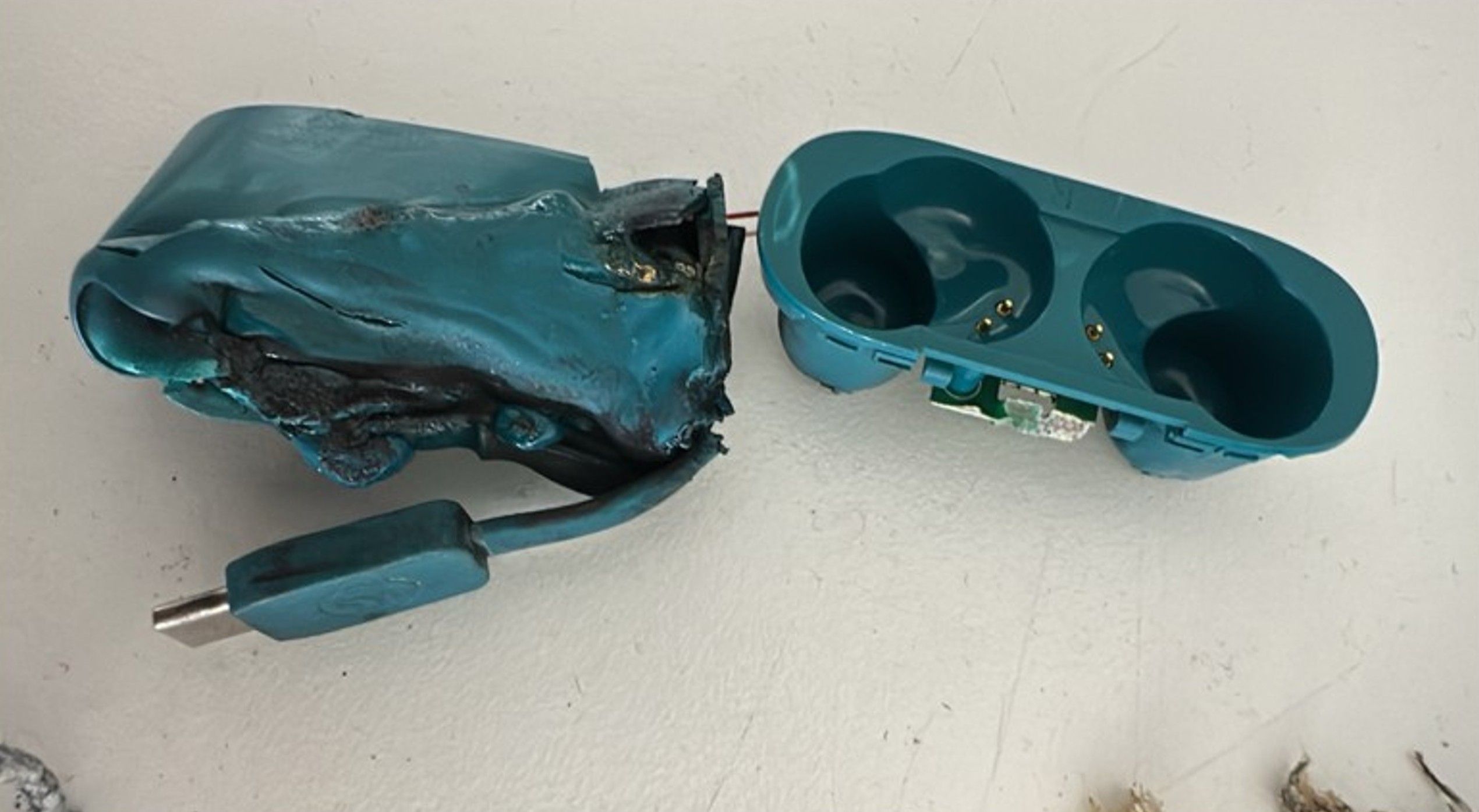 Geschmolzenes, zerdrücktes blaues Kopfhörer-Ladecase vom LX16-Flugunfall.