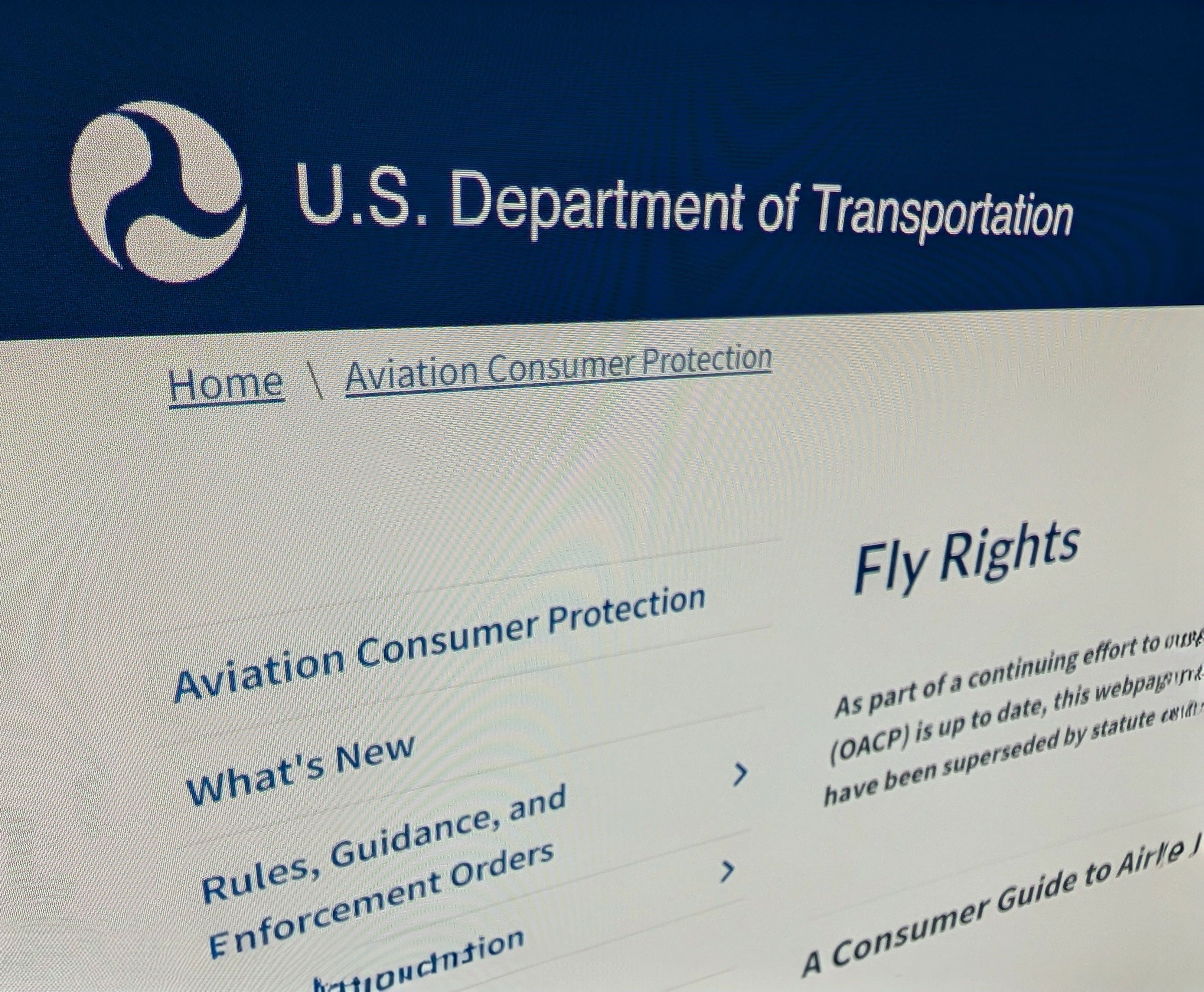 Bildschirm mit der Webseite des U.S. Department of Transportation: „Aviation Consumer Protection“ und „Fly Rights“.