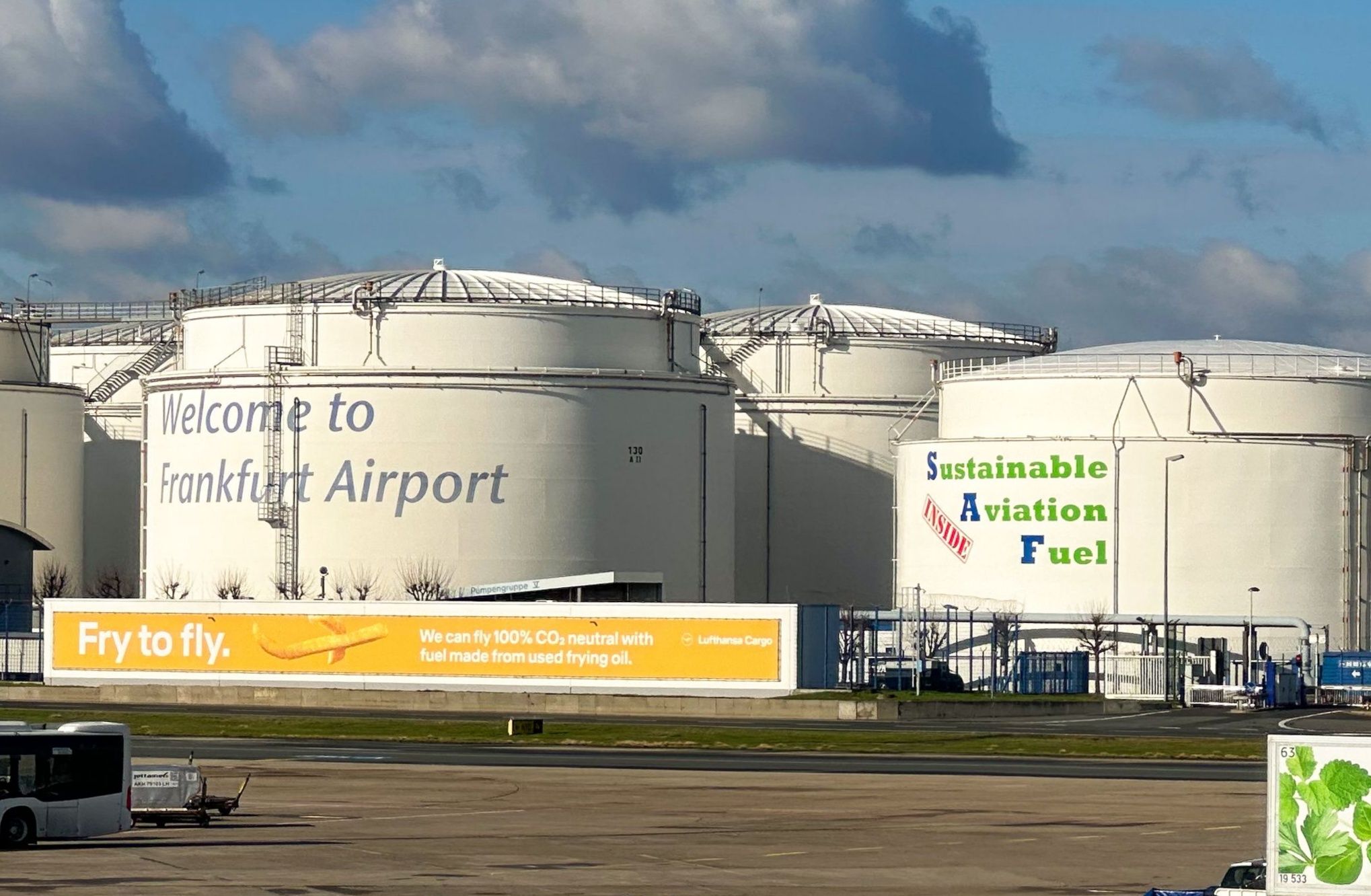 Fuel storage tanks at Frankfurt Airport featuring sustainable aviation fuel branding.