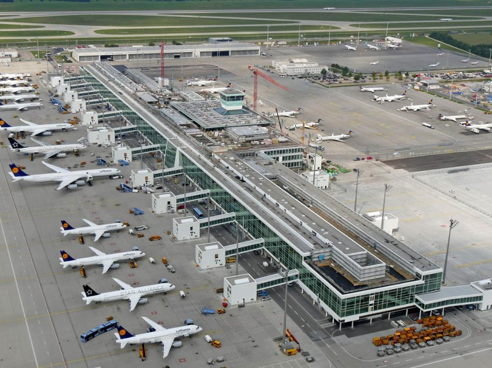 Aerial view of Munich Airport showcasing Lufthansa planes and terminal construction.
